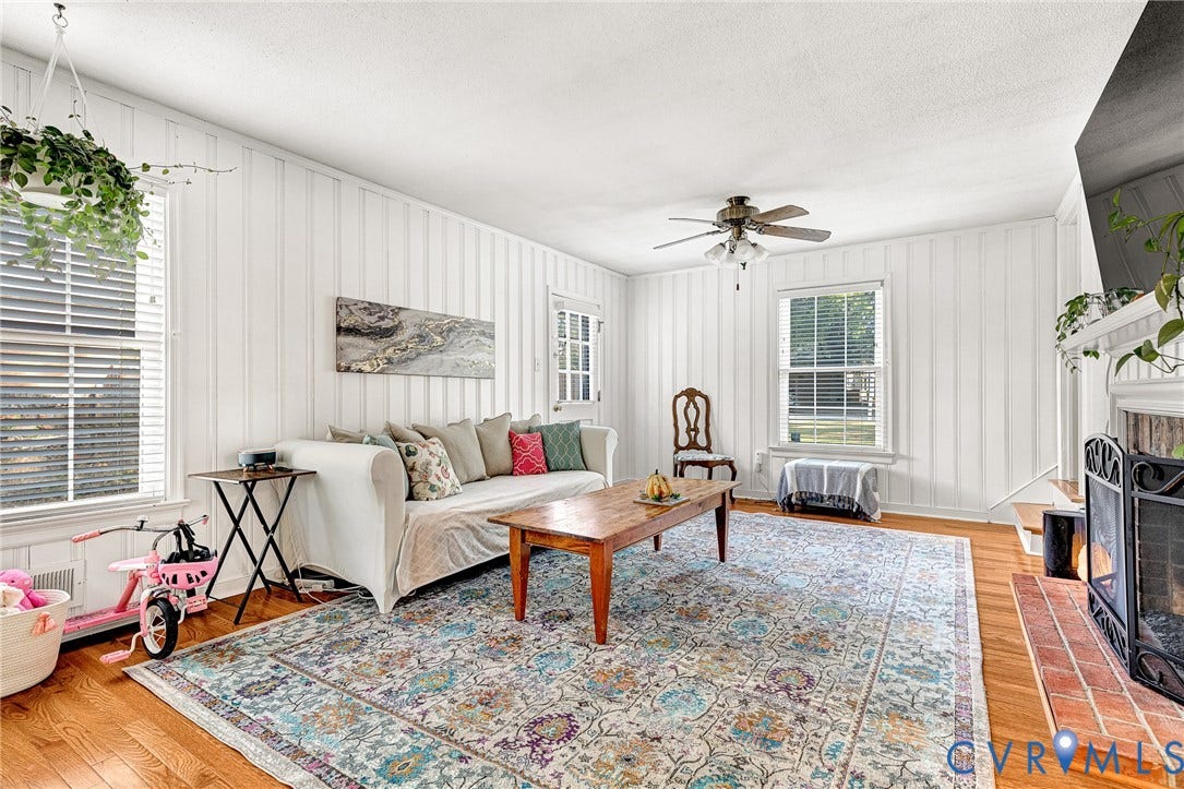1526 Westshire Lane, Henrico, VA 23238 Vertical wood paneling, wood-finish flooring, brick-surround fireplace, and ceiling fan with integrated lighting