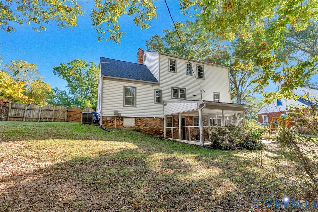 1526 Westshire Lane, Henrico, VA 23238 Rear exterior featuring light-colored horizontal siding, a lower-level brick facade, a screened-in patio, and a fenced backyard