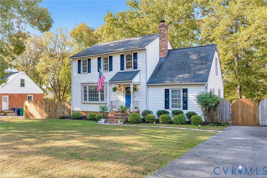 1526 Westshire Lane, Henrico, VA 23238 Colonial-style exterior featuring white horizontal siding, dark blue shutters, a central brick chimney, a covered front entry with brick steps, and a multi-level asphalt shingle roof
