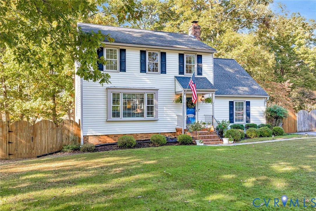 1526 Westshire Lane, Henrico, VA 23238 Two-story exterior featuring light-colored horizontal siding, dark shutters, a front entry with a covered porch, brick steps, and a multi-pane bay window