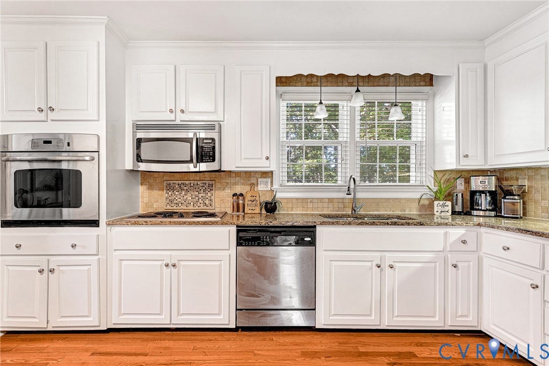 1526 Westshire Lane, Henrico, VA 23238 Kitchen featuring white cabinetry, stone countertops, stainless steel appliances including a built-in wall oven and microwave, stone tile backsplash, and wood-finish flooring