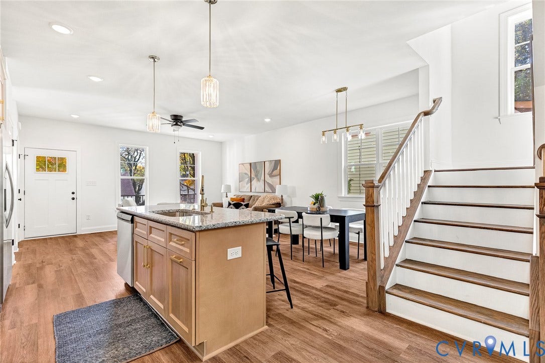 1807.5 Gordon Avenue, Oak Grove, Oak Grove, VA 23224 Open-concept kitchen featuring a stone-topped island with shaker-style cabinetry, wood-finish flooring, recessed lighting, and a wooden staircase with white balusters