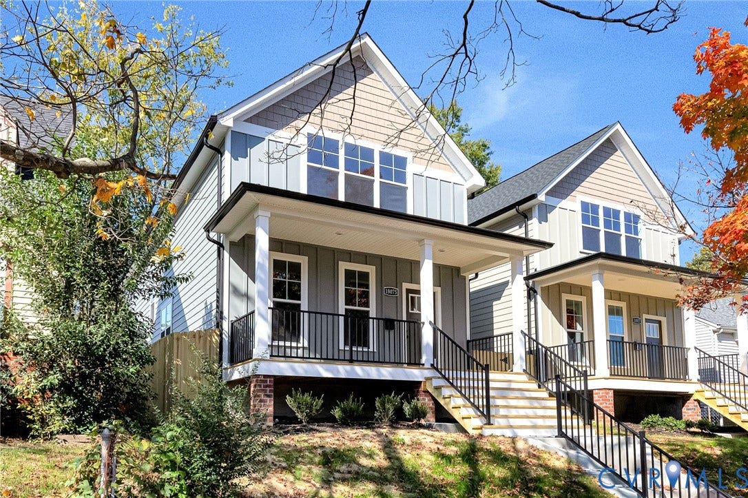 1807.5 Gordon Avenue, Oak Grove, Oak Grove, VA 23224 Gabled exterior featuring board-and-batten siding, a covered front porch, brick foundation detailing, and black metal railings