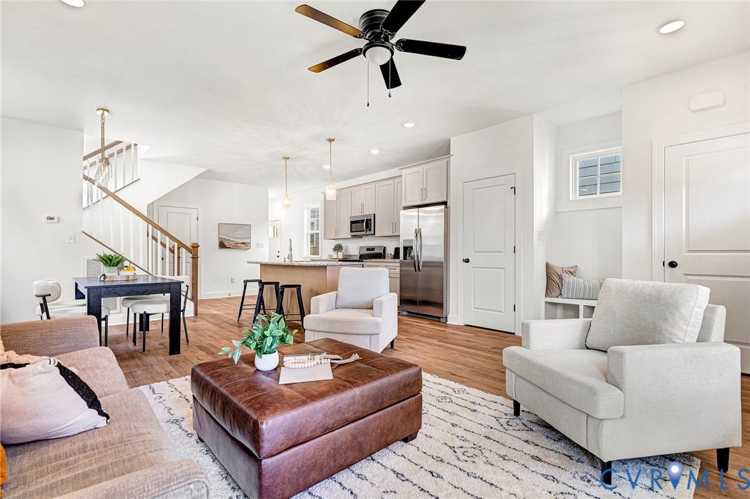 1807.5 Gordon Avenue, Oak Grove, Oak Grove, VA 23224 Open-concept interior featuring wood-finish flooring, a kitchen with stainless steel appliances, a center island with pendant lighting, a recessed staircase with a wooden handrail, and built-in bench seating