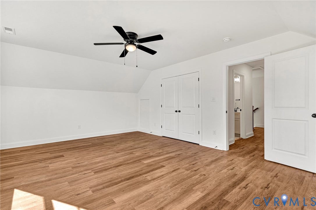 1807.5 Gordon Avenue, Oak Grove, Oak Grove, VA 23224 Room featuring wood-finish flooring, a matte black ceiling fan with integrated lighting, slanted ceilings, double-panel interior doors, and a reach-in closet