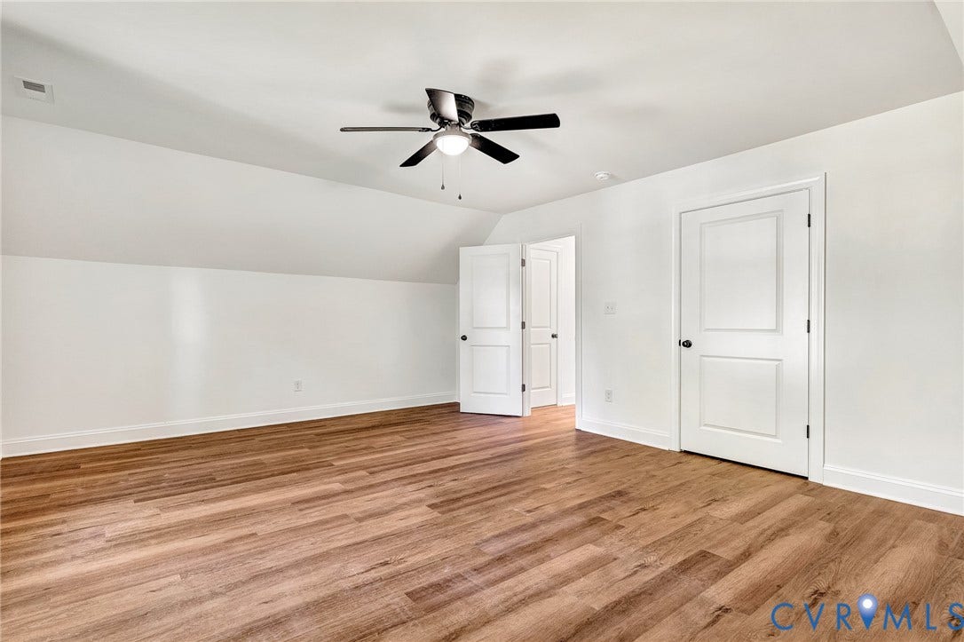 1807.5 Gordon Avenue, Oak Grove, Oak Grove, VA 23224 Room interior featuring wood-finish flooring, vaulted ceiling, dual-panel interior doors, and a central ceiling fan with integrated light