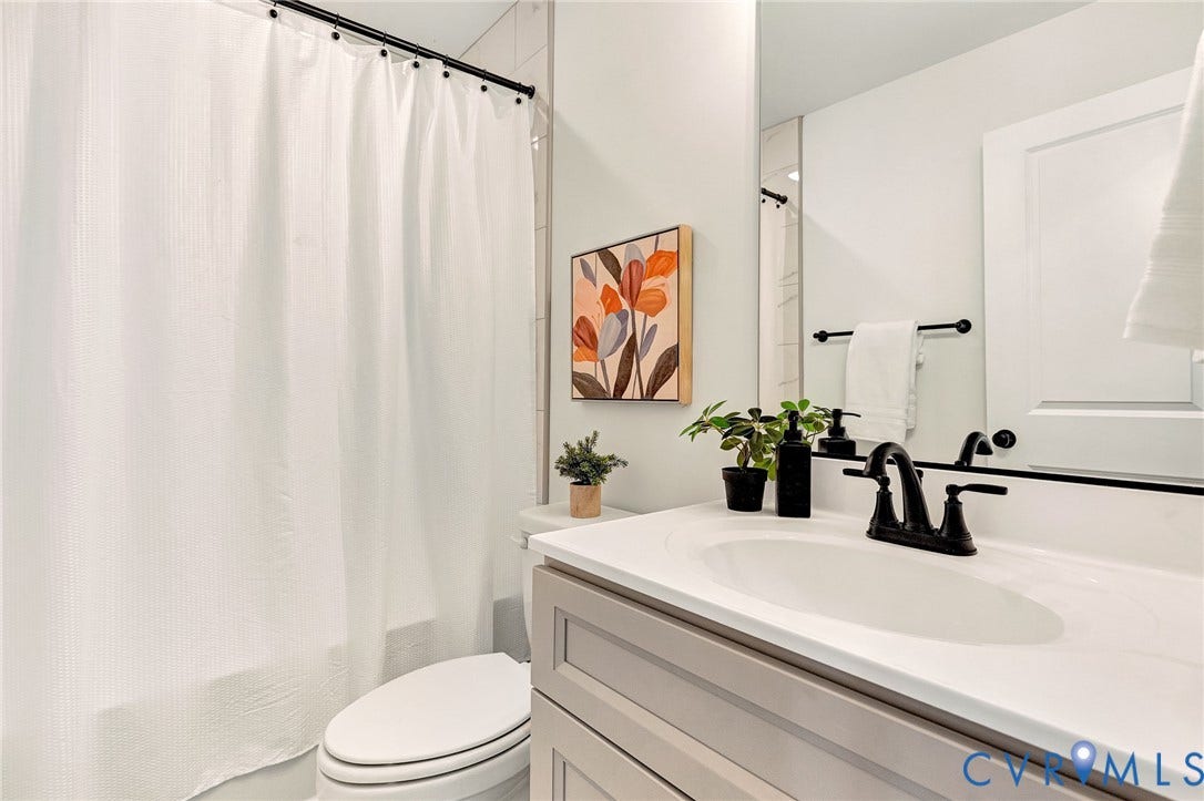 1807.5 Gordon Avenue, Oak Grove, Oak Grove, VA 23224 Bathroom featuring a vanity with shaker-style cabinetry, an integrated sink, matte black plumbing fixtures, a full-width mirror, and a tub-shower combination with floor-to-ceiling tile surround