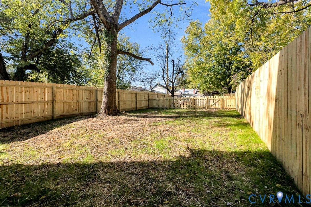 1807.5 Gordon Avenue, Oak Grove, Oak Grove, VA 23224 Fenced backyard featuring wood privacy fencing, a gate, mature trees, and grass lawn