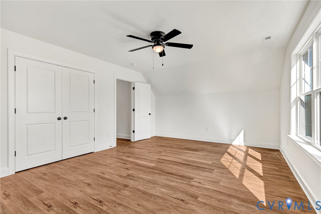 1807.5 Gordon Avenue, Oak Grove, Oak Grove, VA 23224 Wood-finish flooring, white double-panel closet doors, and a ceiling fan with integrated lighting
