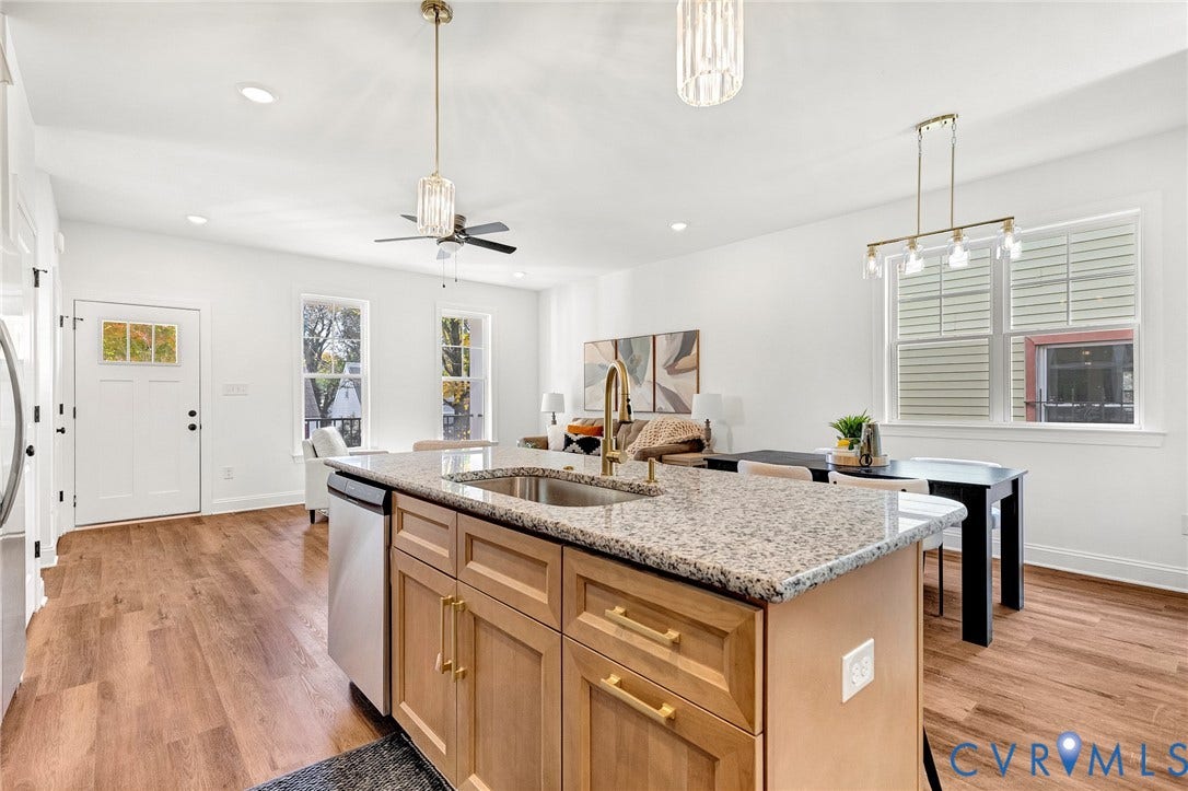 1807.5 Gordon Avenue, Oak Grove, Oak Grove, VA 23224 Kitchen island with stone countertop, undermount sink, and metallic faucet, complemented by wood-finish flooring and pendant lighting
