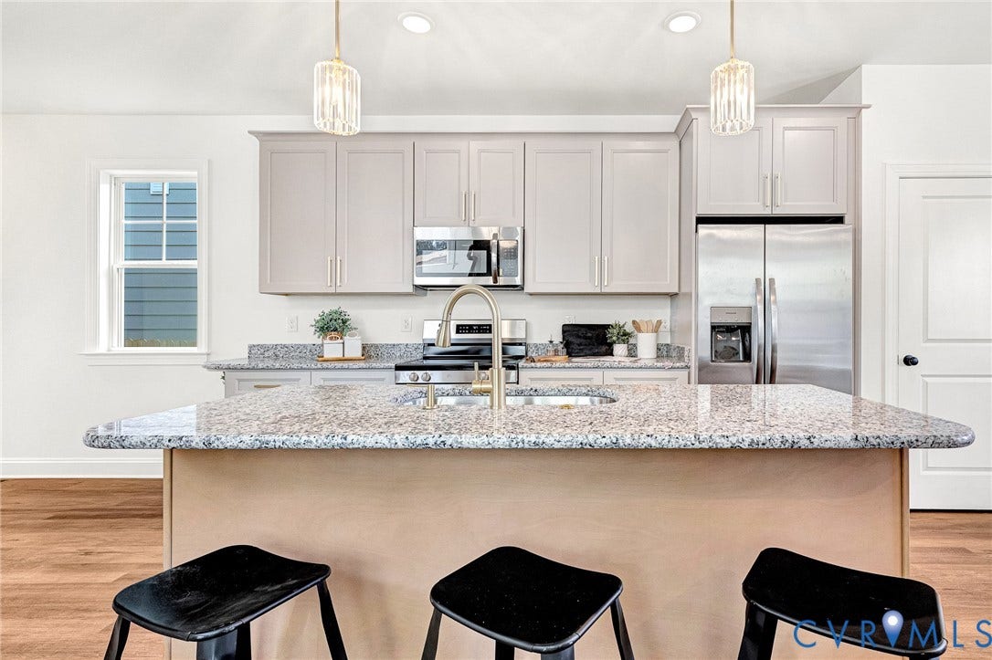 1807.5 Gordon Avenue, Oak Grove, Oak Grove, VA 23224 Kitchen featuring stone countertops, central island with an undermount sink, stainless steel appliances, light-toned cabinetry, and decorative pendant lighting