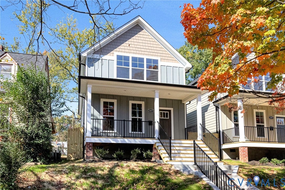 1807.5 Gordon Avenue, Oak Grove, Oak Grove, VA 23224 Two-story exterior featuring vertical board-and-batten siding, shake-shingle gables, a covered front porch with metal railings, and a brick-accented foundation