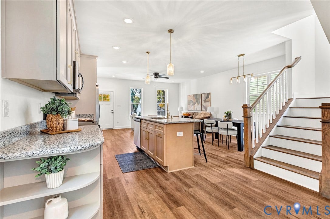 1807.5 Gordon Avenue, Oak Grove, Oak Grove, VA 23224 Kitchen featuring a central island with stone-style countertops, light-finish cabinetry, wood-finish flooring, recessed lighting, and a staircase with a wooden handrail and white balusters