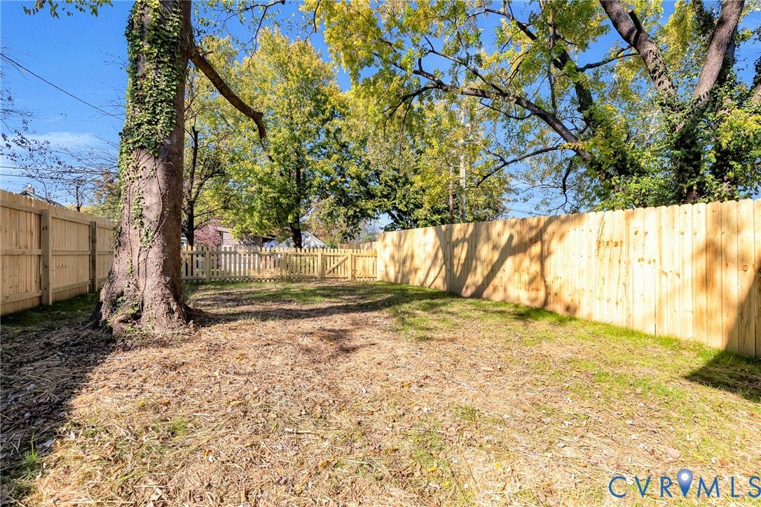 1807.5 Gordon Avenue, Oak Grove, Oak Grove, VA 23224 Backyard featuring a wood-panel fence, gated entry, and mature trees
