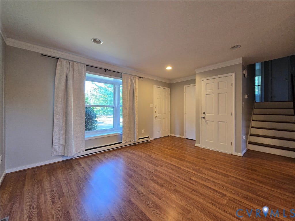 Interior space featuring wood-finish flooring, recessed lighting, crown molding, a multi-pane bay window, and six-panel doors