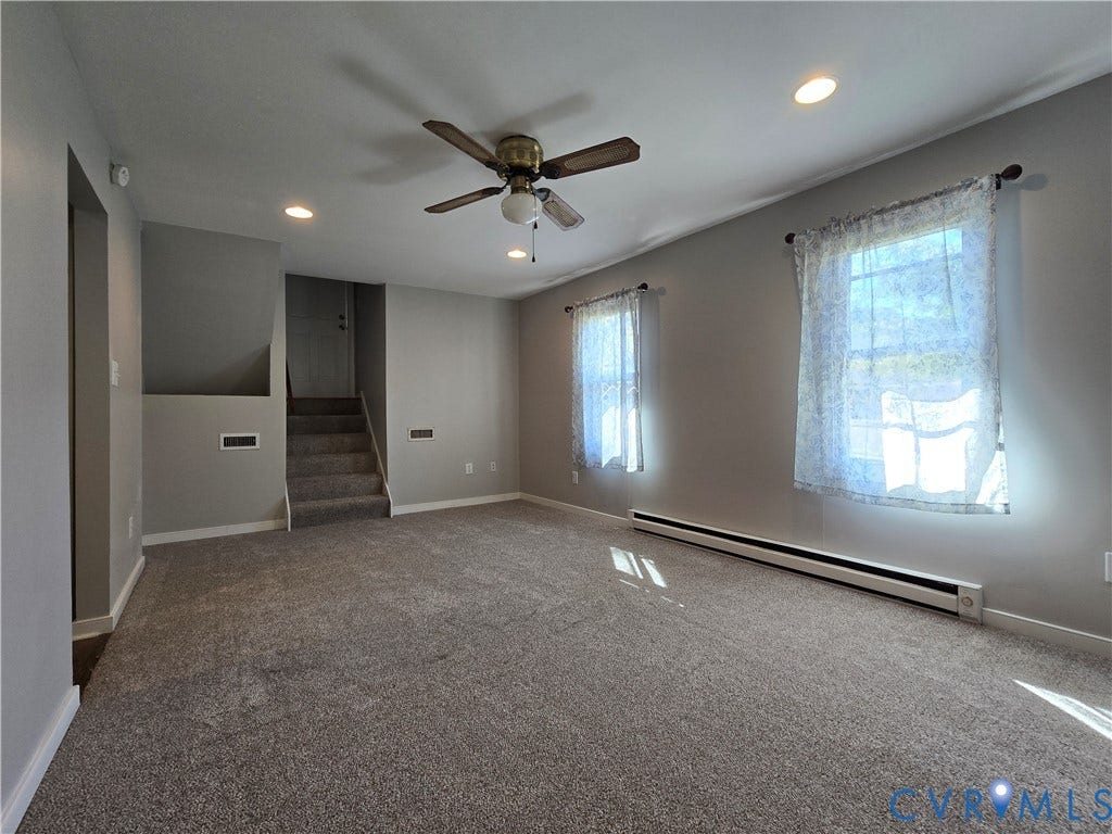 Room with neutral-toned carpeting, recessed ceiling lighting, dual windows, and a ceiling fan with integrated light fixture