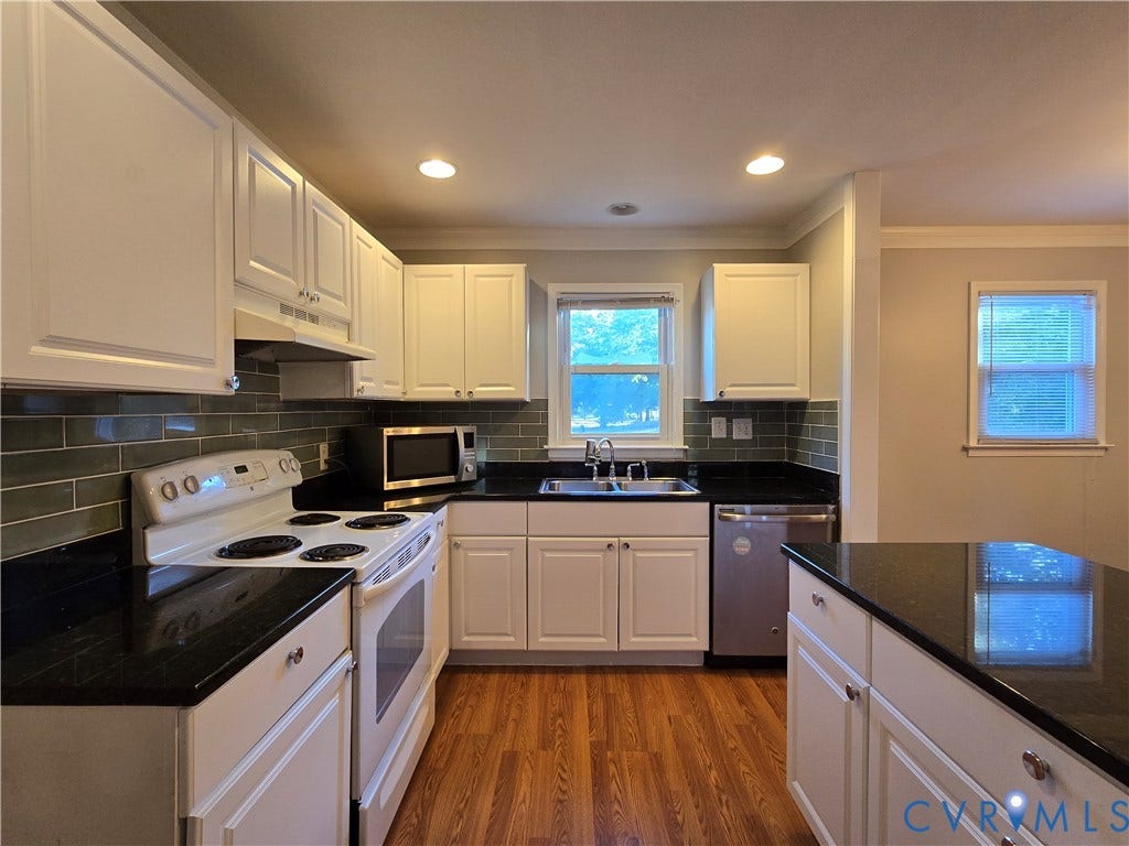 Kitchen featuring white cabinetry, dark stone countertops, subway tile backsplash, recessed lighting, and wood-finish flooring