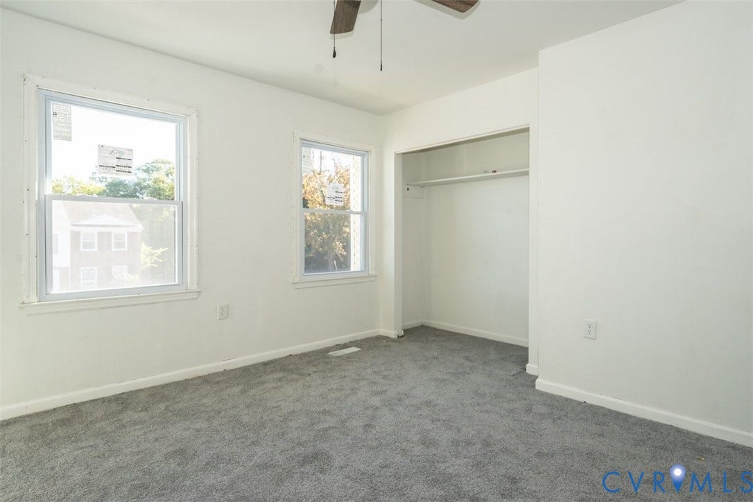 2358 Hill Street, #G, Petersburg, VA 23803 Neutral-toned interior space featuring wall-to-wall carpeting, dual-pane windows, a recessed closet with overhead shelving, and a ceiling fan