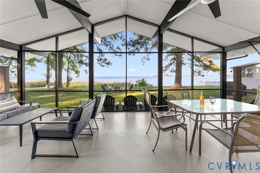 Screened porch featuring a vaulted ceiling with exposed beams, expansive floor-to-ceiling window walls, and concrete flooring