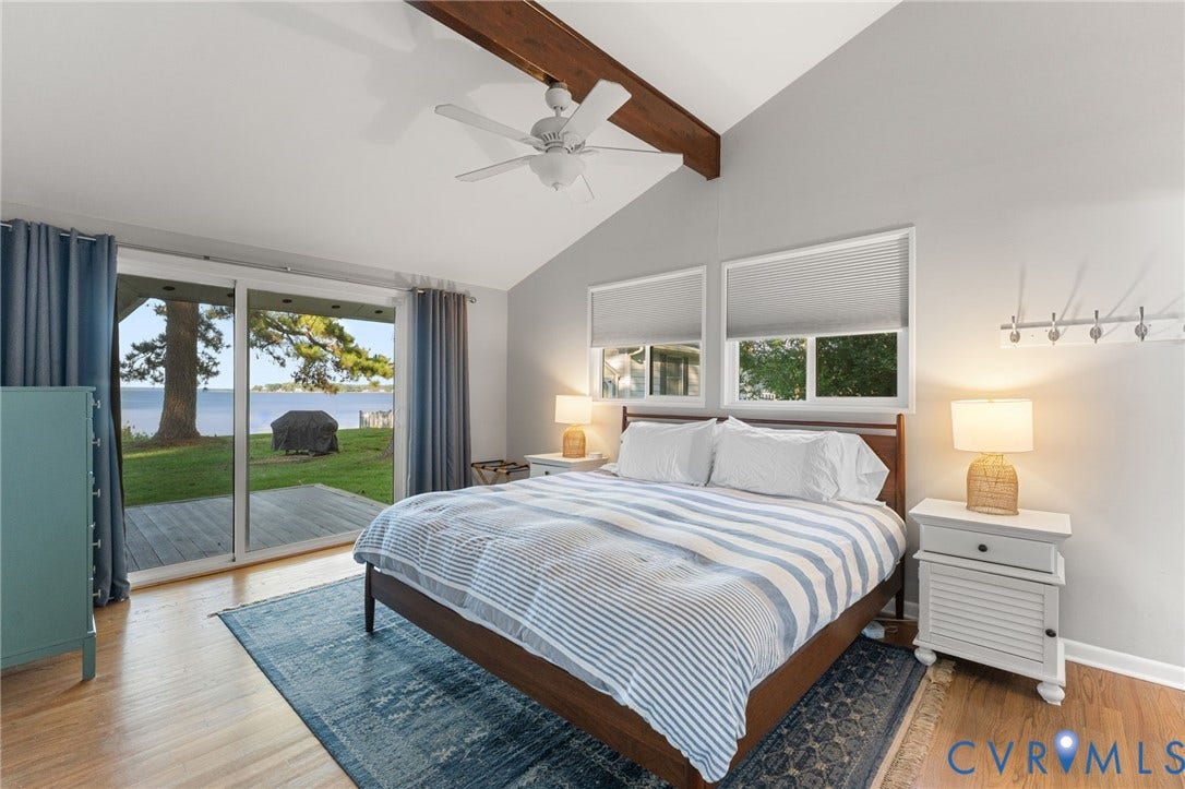 Vaulted ceiling featuring an exposed wood beam, wood-finish flooring, and a ceiling fan