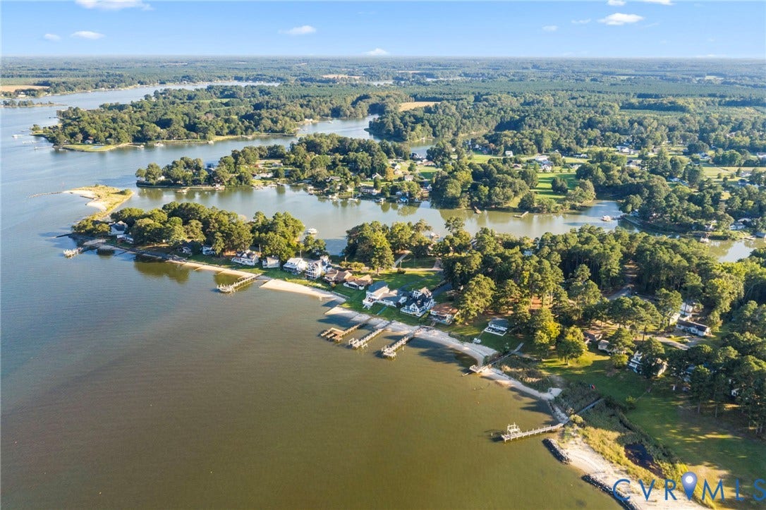 Aerial perspective featuring expansive waterfront acreage, private shoreline, and multiple deep-water wooden docks