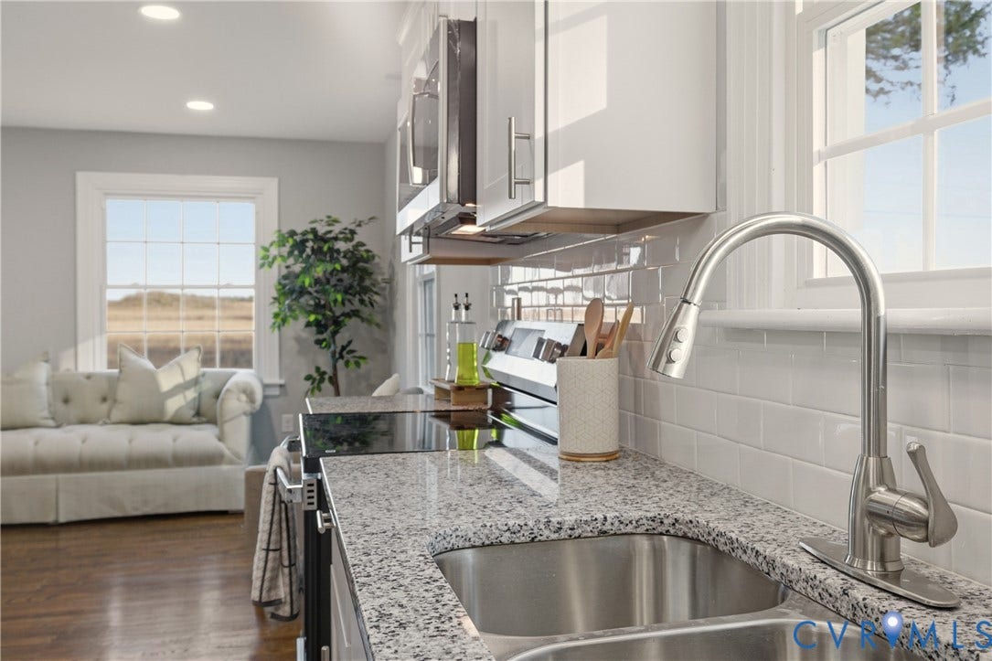 6280 Monahan Road, Henrico, VA 23231 Kitchen featuring stone countertops, stainless steel undermount double sink, brushed nickel high-arc pull-down faucet, white subway tile backsplash, and white cabinetry