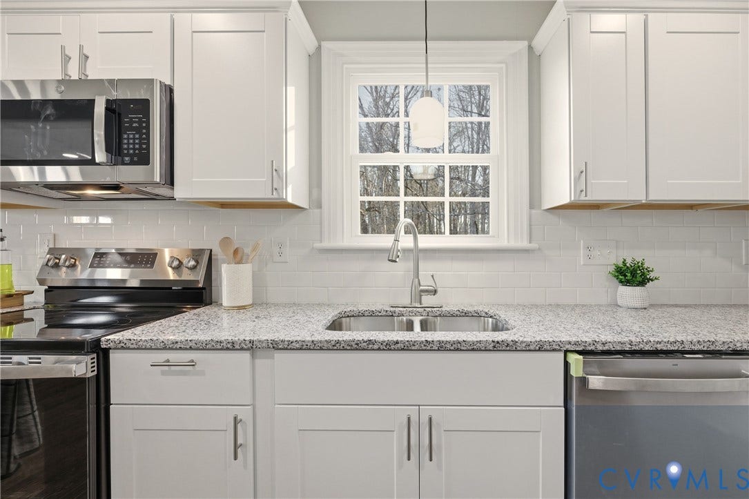 6280 Monahan Road, Henrico, VA 23231 Kitchen featuring white shaker-style cabinetry, stainless steel appliances, a multi-tonal stone-surface countertop, white subway tile backsplash, and an undermount sink with a high-arc pull-down faucet