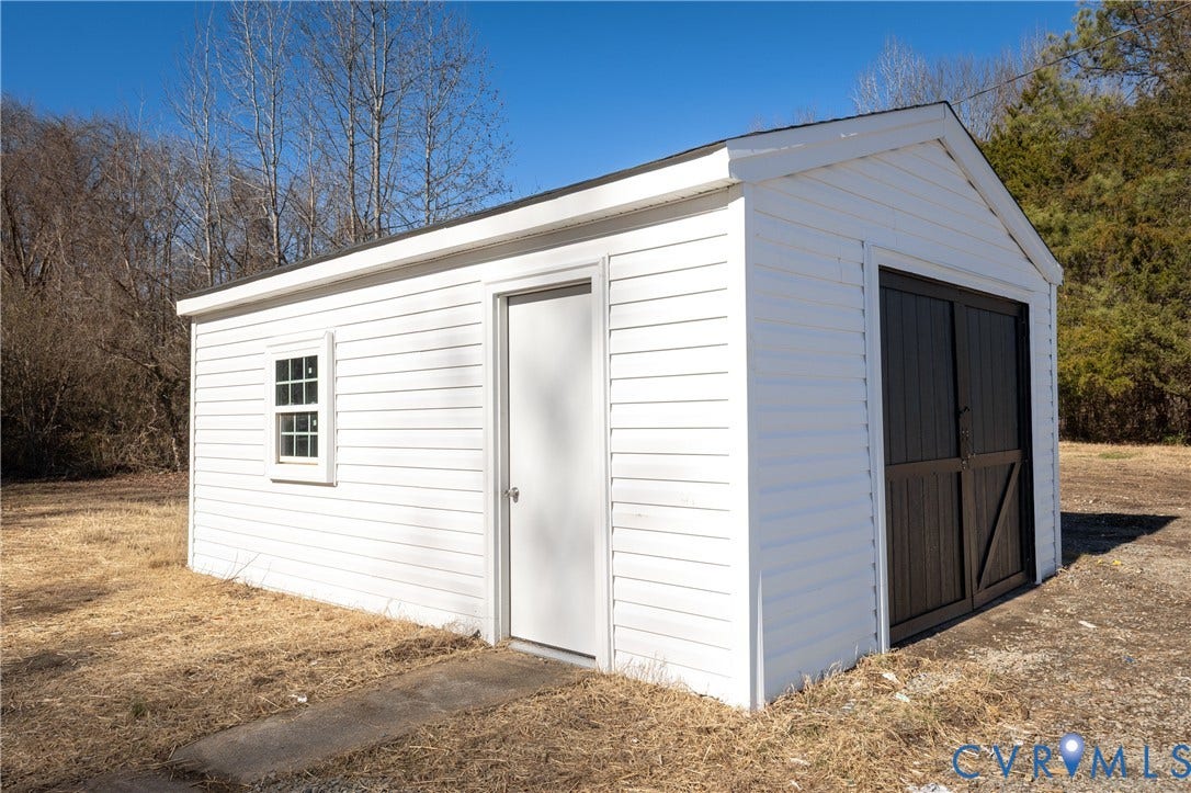 6280 Monahan Road, Henrico, VA 23231 Detached utility structure featuring white horizontal siding, a single-pane window, a side-access door, and dark-finished double barn-style doors