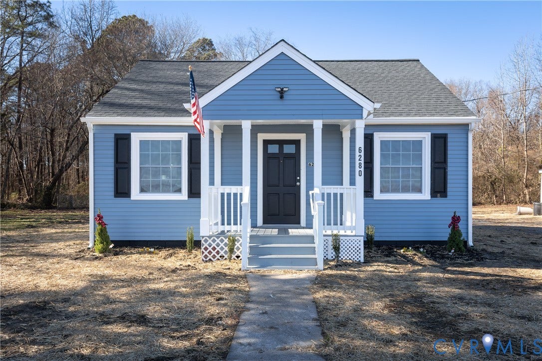 6280 Monahan Road, Henrico, VA 23231 Blue siding exterior with contrasting black shutters, front porch with white railing, asphalt shingle roof, and a paved walkway