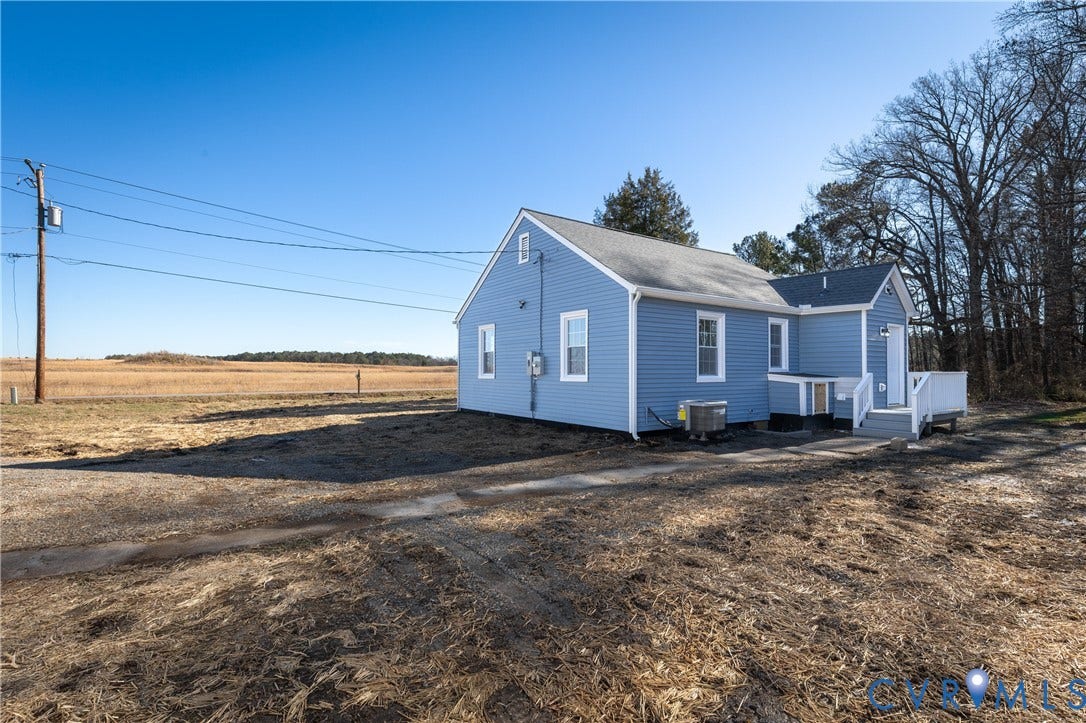 6280 Monahan Road, Henrico, VA 23231 Blue horizontal lap siding exterior featuring a gable roof, white-trimmed windows, and a raised wooden deck with white railing