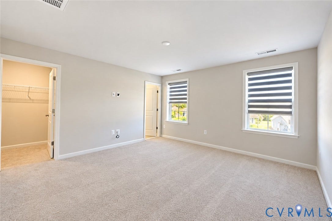 500 Rivanna Hill Way, Glen Allen, VA 23060 Neutral-toned room featuring plush wall-to-wall carpeting, dual windows with banded roller shades, and a walk-in closet with built-in wire shelving