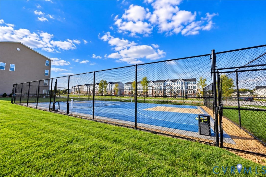 500 Rivanna Hill Way, Glen Allen, VA 23060 Multi-purpose athletic court featuring a blue and tan surface, enclosed by black chain-link fencing, situated within a manicured grass lawn