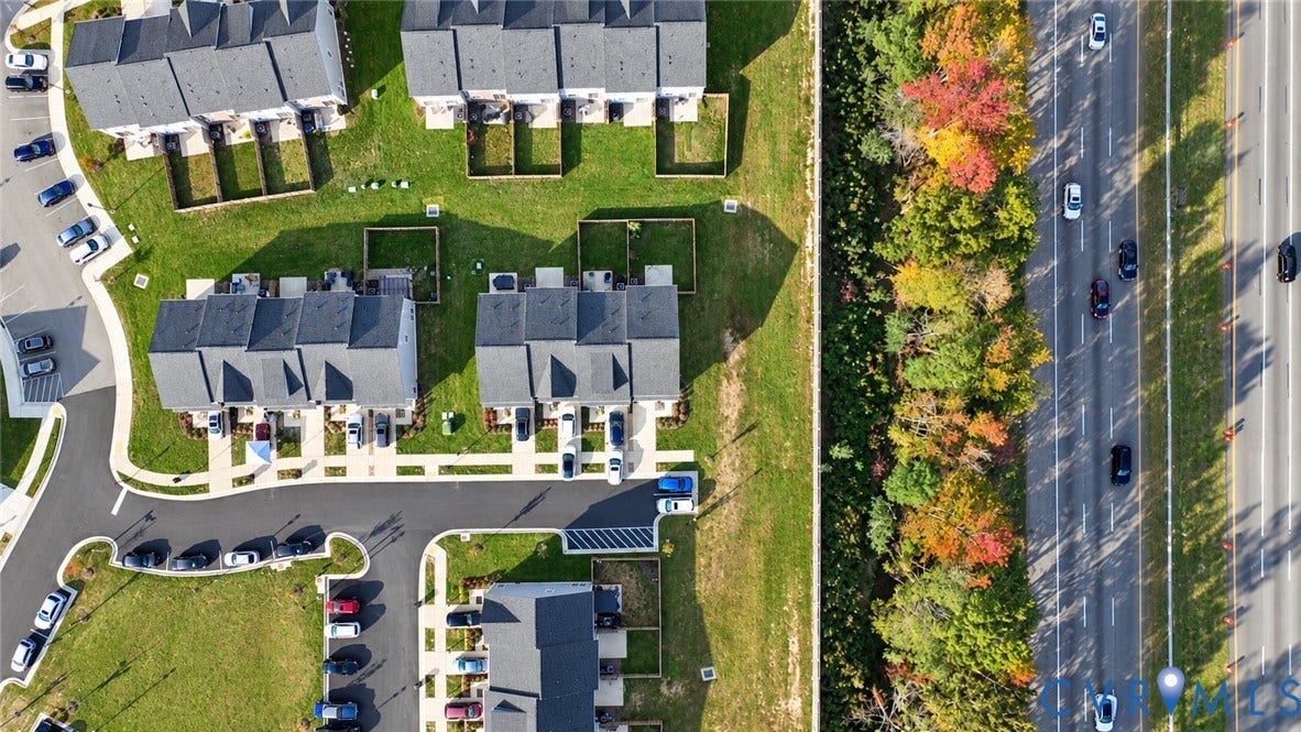 500 Rivanna Hill Way, Glen Allen, VA 23060 Aerial perspective of townhome community featuring asphalt roadways, designated parking areas, sodded green space, and mature trees