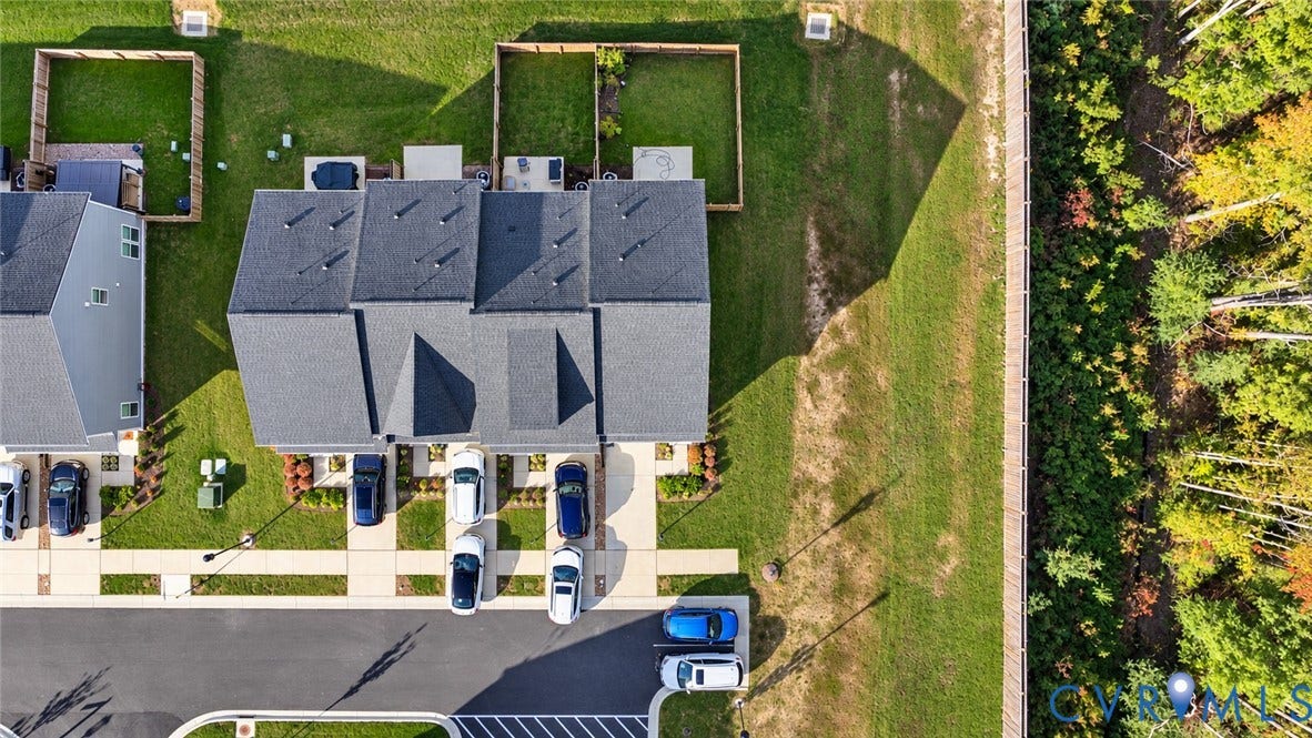 500 Rivanna Hill Way, Glen Allen, VA 23060 Aerial perspective featuring a multi-unit structure with dark shingle roofing, concrete driveways, individual fenced-in backyard areas, and perimeter woodland buffering