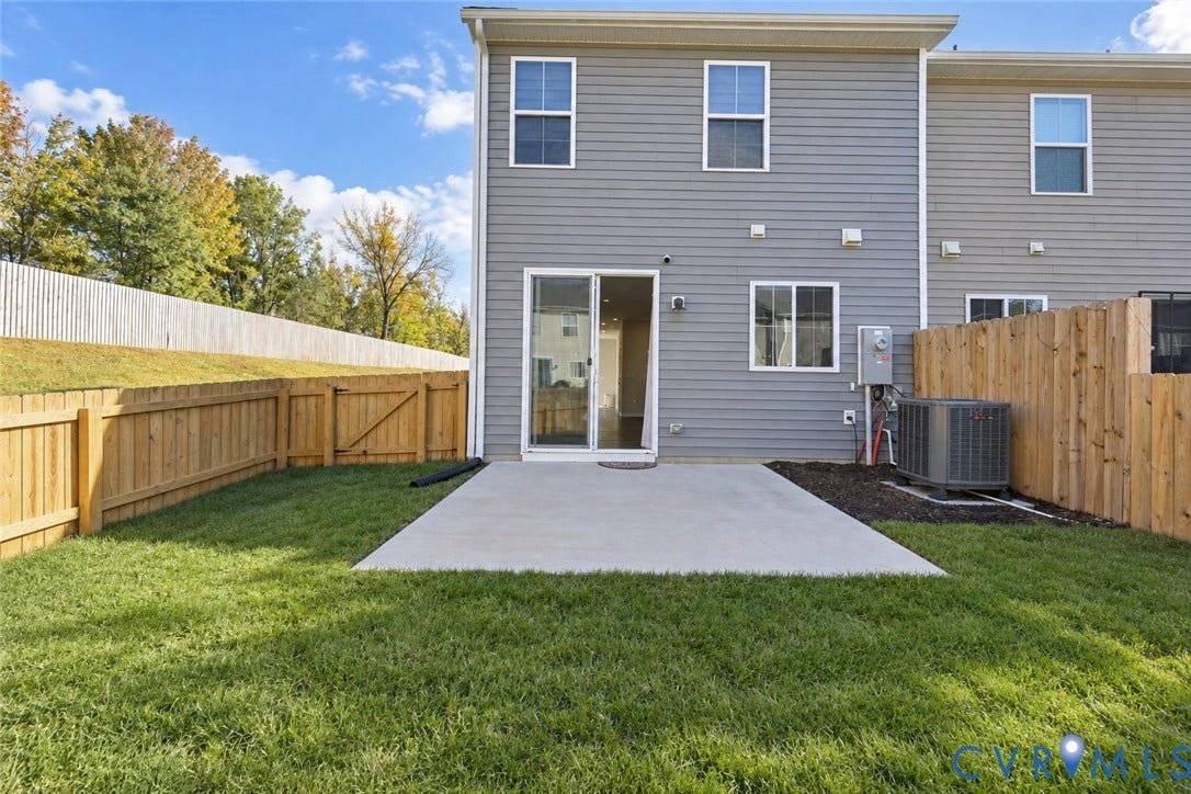500 Rivanna Hill Way, Glen Allen, VA 23060 Rear exterior featuring gray horizontal siding, a concrete patio, a fenced yard, and a sliding glass door