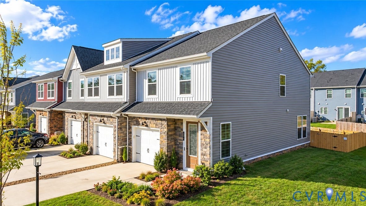 500 Rivanna Hill Way, Glen Allen, VA 23060 Multi-level townhouse featuring a mixed-material facade of stone veneer and horizontal siding, an attached garage, and a gable roof with dormer windows