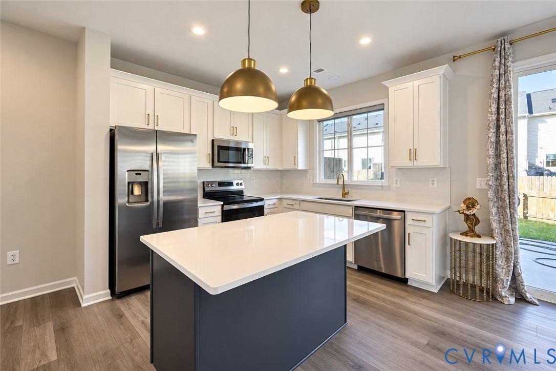 500 Rivanna Hill Way, Glen Allen, VA 23060 Kitchen featuring white cabinetry, an island with a quartz countertop, stainless steel appliances, dual brass-finish pendant lights, and wood-finish flooring