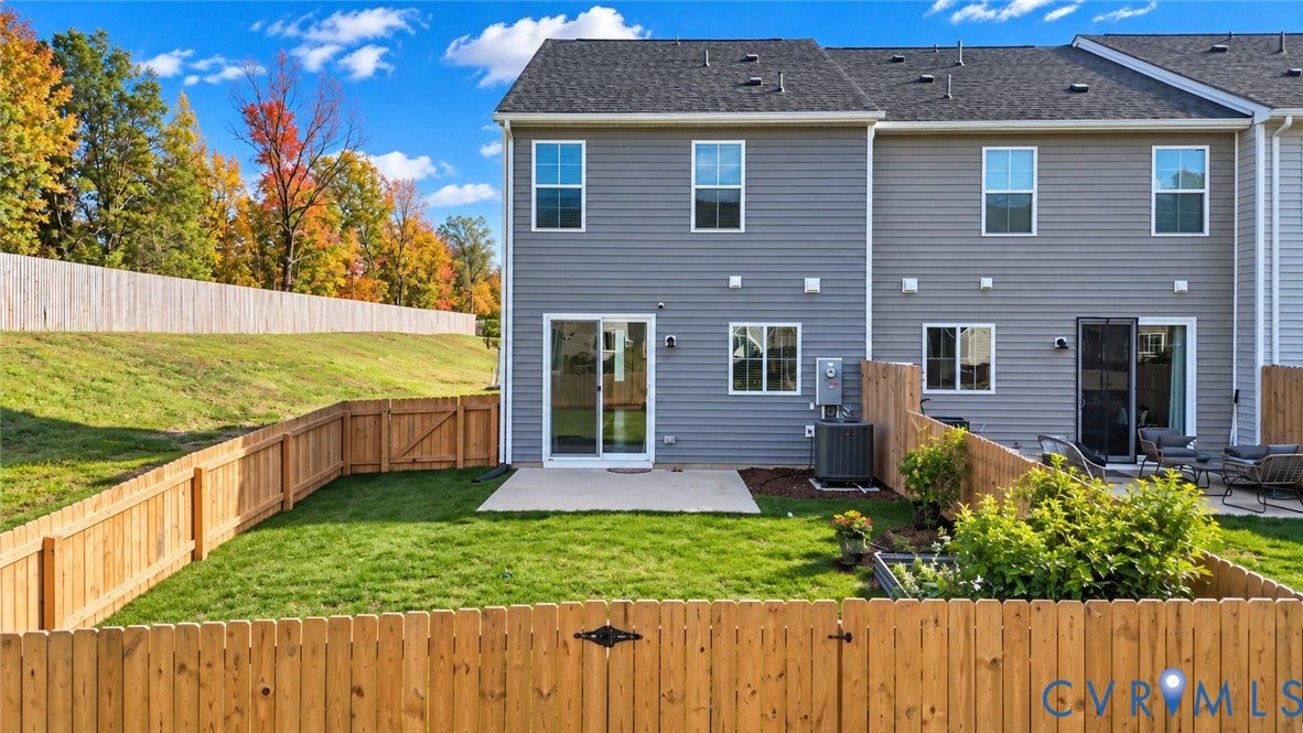 500 Rivanna Hill Way, Glen Allen, VA 23060 Grey horizontal siding exterior featuring a private backyard, wood-plank fencing, concrete patio, and sliding glass entry door
