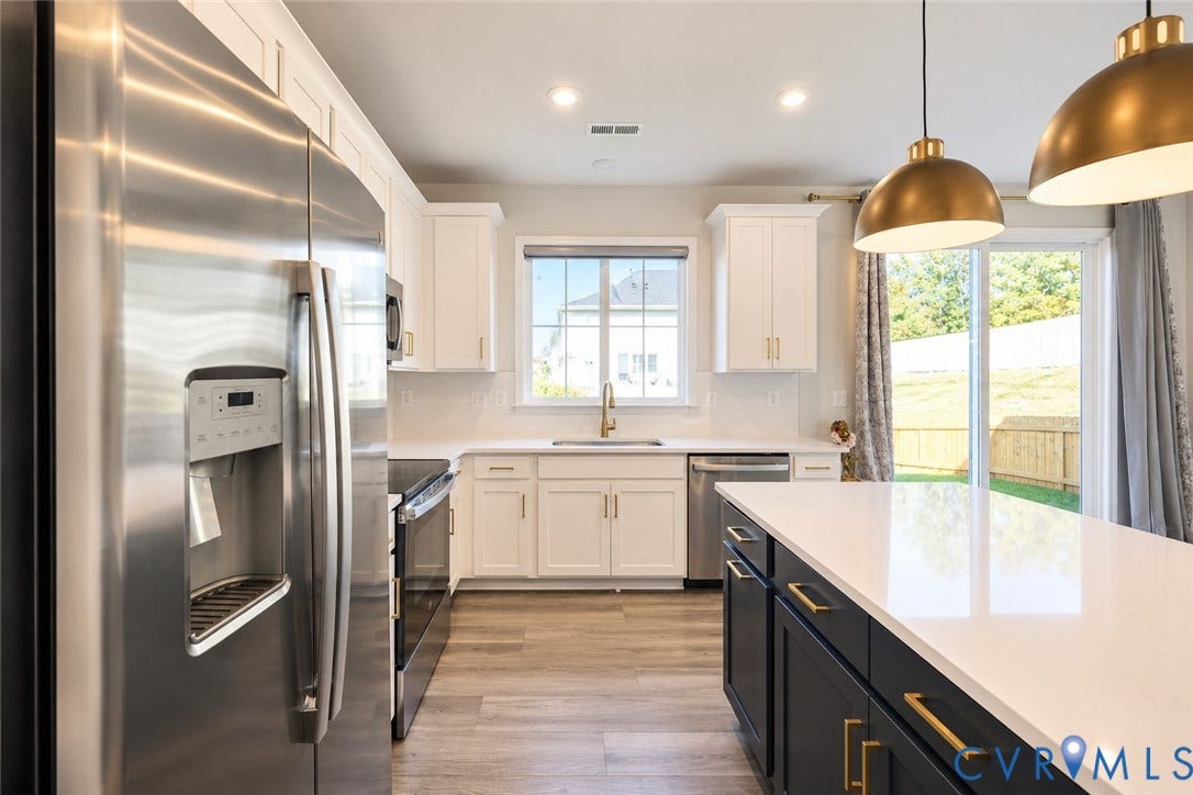500 Rivanna Hill Way, Glen Allen, VA 23060 Kitchen featuring white upper cabinetry, a dark-toned center island with a quartz countertop, stainless steel appliances, brass-finish pendant lighting, and wood-finish flooring