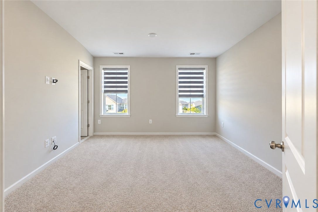 500 Rivanna Hill Way, Glen Allen, VA 23060 Neutral-toned room featuring plush wall-to-wall carpeting, dual windows with integrated shades, and a six-panel door
