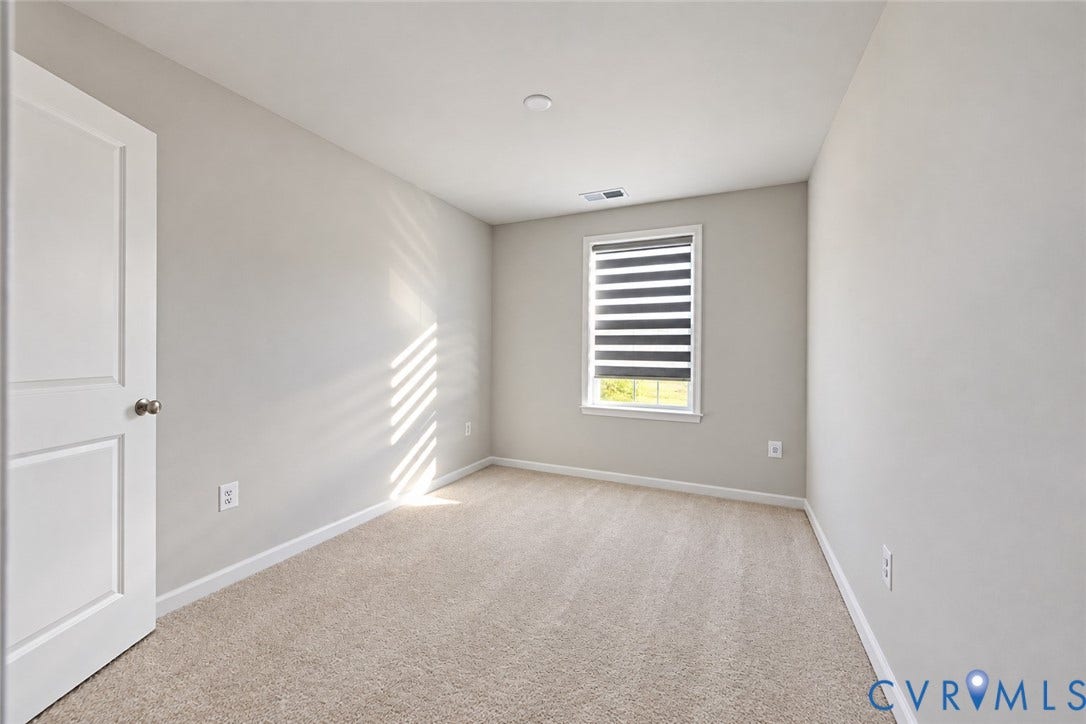 500 Rivanna Hill Way, Glen Allen, VA 23060 Interior room featuring neutral-toned carpeting, light-colored walls, a single-panel interior door, and a window equipped with striped roller shades