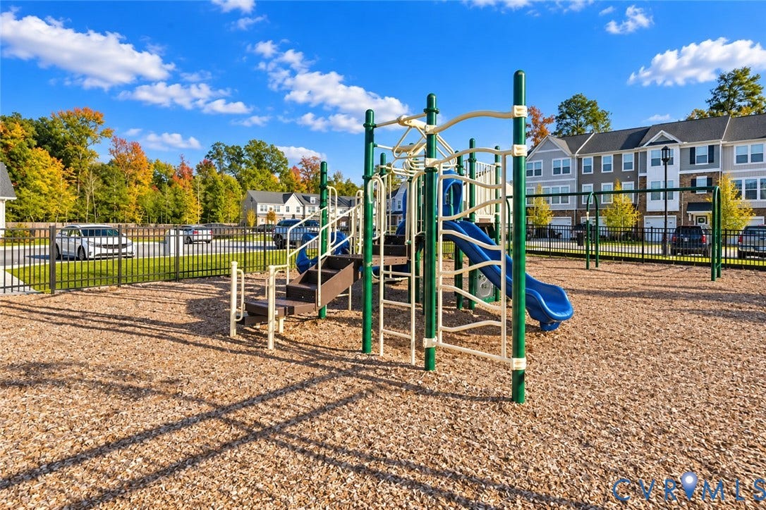 500 Rivanna Hill Way, Glen Allen, VA 23060 Community playground featuring a multi-level structure with a slide, climbing bars, stairs, and a wood-mulch surface enclosed by perimeter fencing