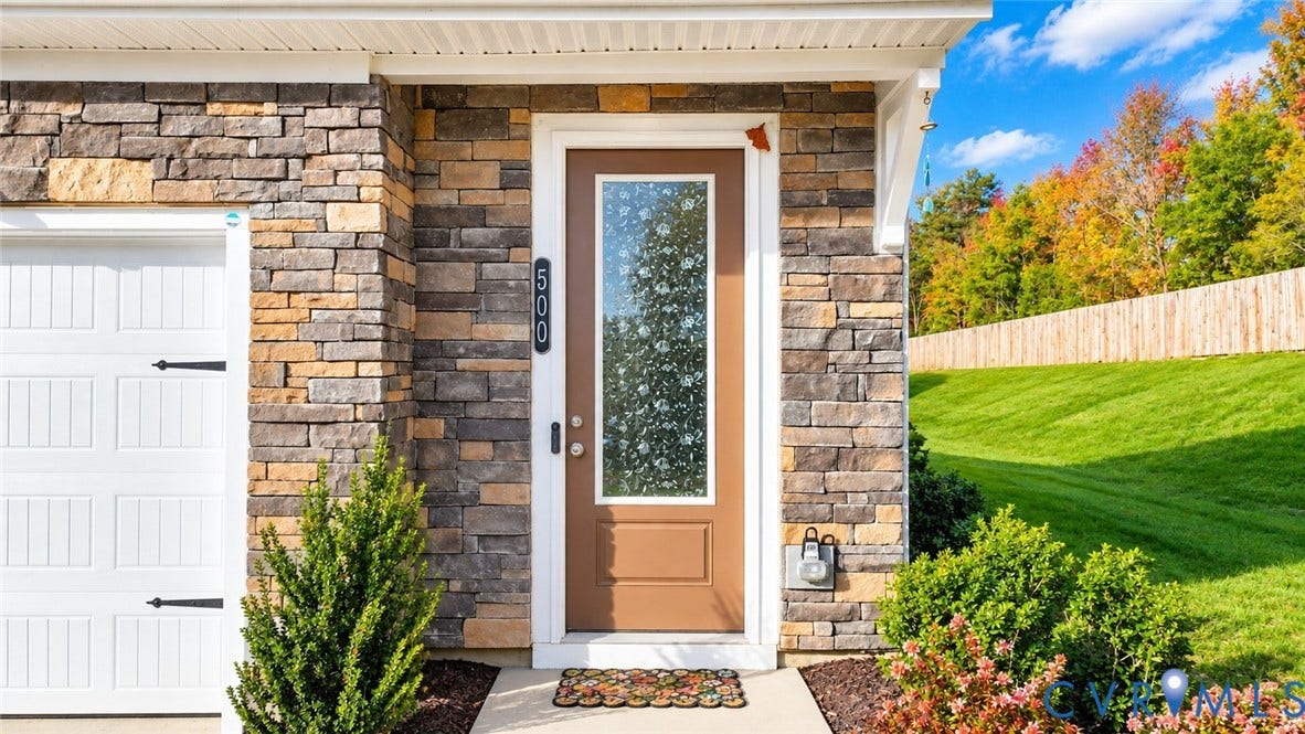 500 Rivanna Hill Way, Glen Allen, VA 23060 Exterior facade featuring stacked stone veneer, white garage door with decorative hardware, and a solid-panel entry door with a vertical glass insert