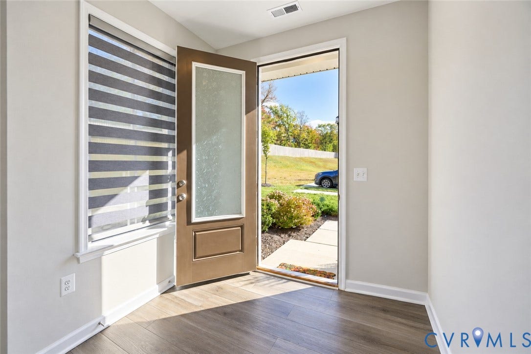 500 Rivanna Hill Way, Glen Allen, VA 23060 Entryway featuring wood-finish flooring, a solid-core front door with an integrated frosted glass panel, and a multi-banded roller shade