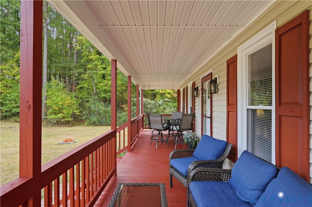 16401 Anderson Drive, Disputanta, VA 23833 Covered front porch featuring painted wood decking, matching railings, vinyl siding, and window shutters