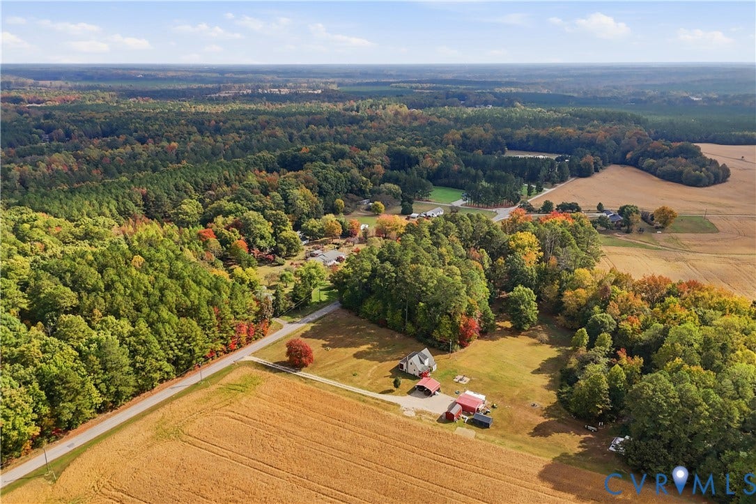 16401 Anderson Drive, Disputanta, VA 23833 Aerial perspective featuring expansive acreage, open fields, forested boundaries, and multiple outbuildings