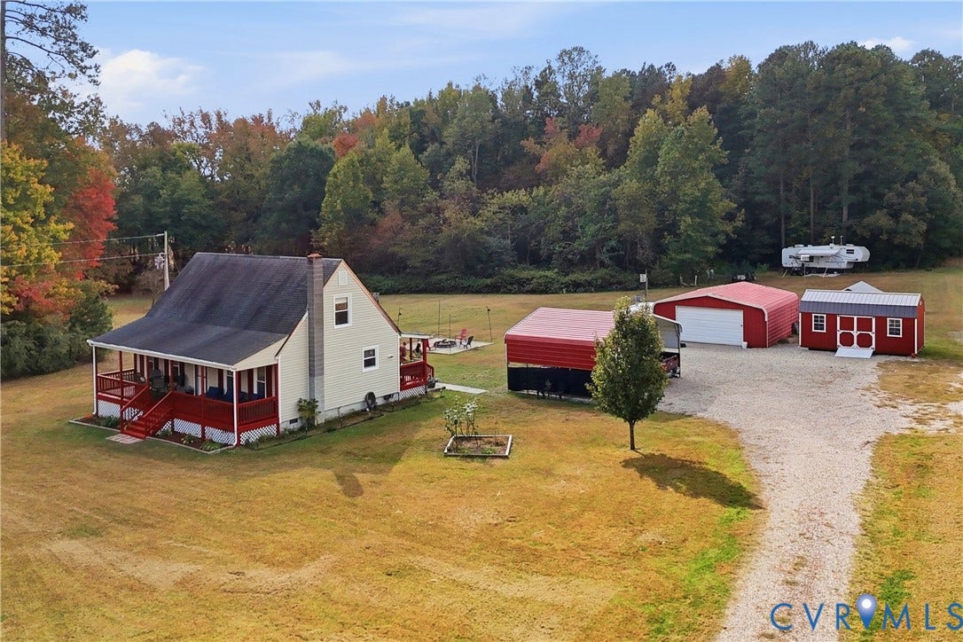 16401 Anderson Drive, Disputanta, VA 23833 Expansive lot featuring a residence with a covered porch, detached garage, storage shed, and metal-roofed carport