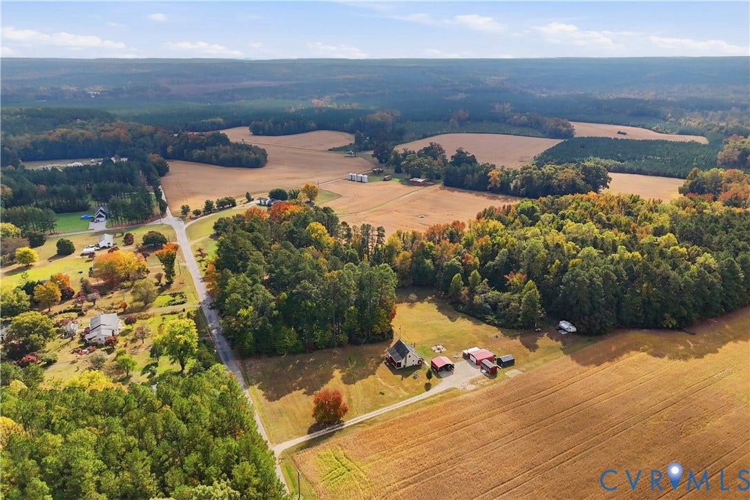 16401 Anderson Drive, Disputanta, VA 23833 Aerial perspective of expansive acreage featuring large tracts of open pasture, mature forested areas, a primary structure, and multiple outbuildings