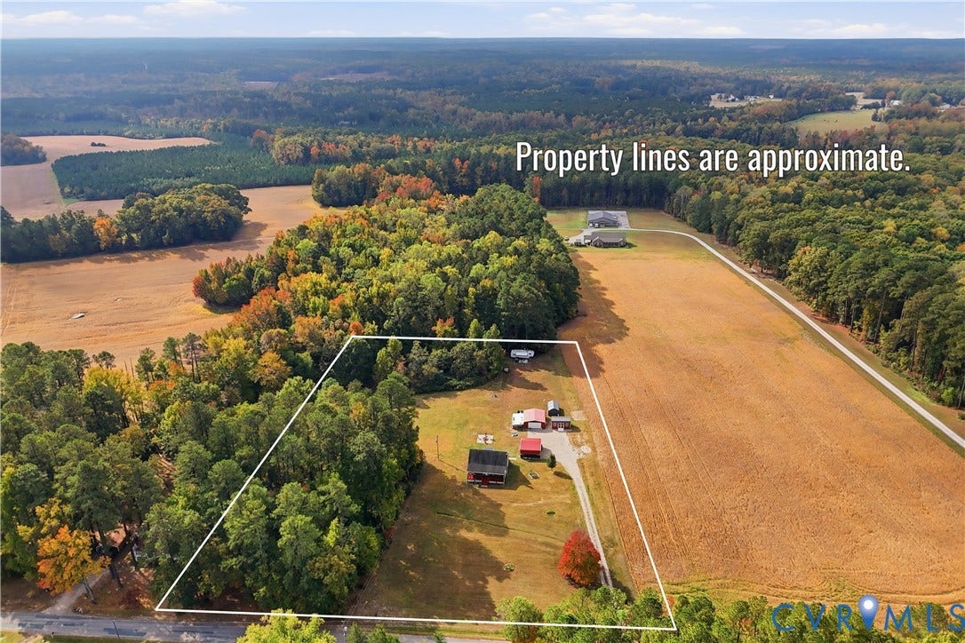 16401 Anderson Drive, Disputanta, VA 23833 Aerial view of acreage featuring wooded areas, open fields, and multiple outbuildings