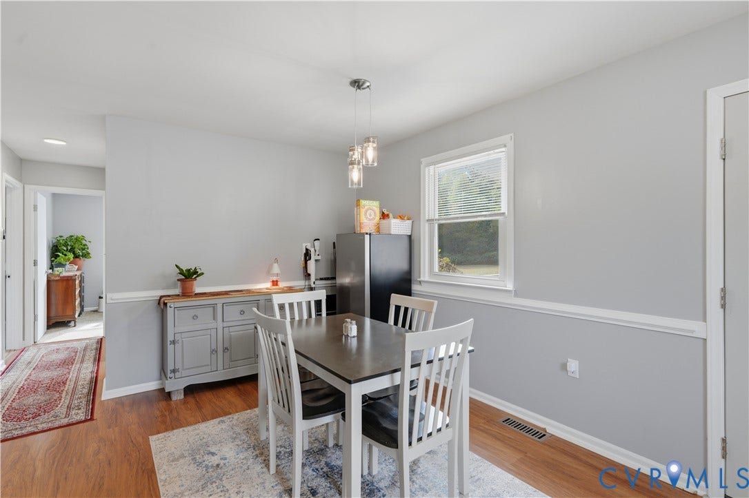 16401 Anderson Drive, Disputanta, VA 23833 Dining area featuring wood-finish flooring, chair rail molding, and three-light glass pendant fixture
